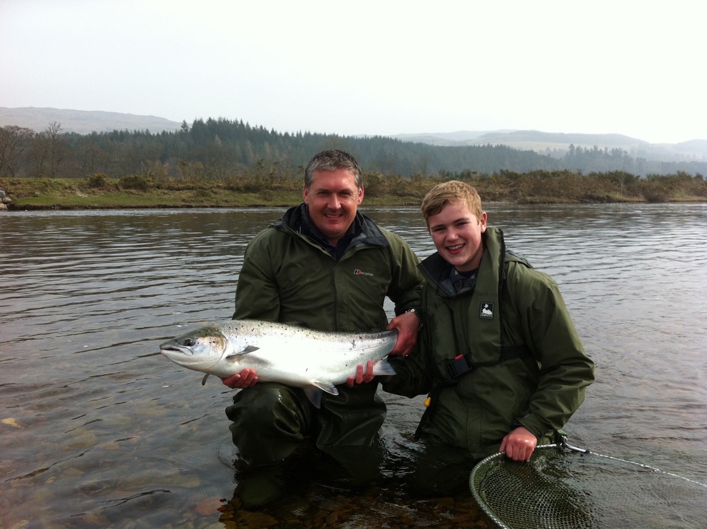 This was myself with a young Glasgow salmon fisher on his first ever salmon fishing trip outing. This big Spring fish weighted 20lbs and was quickly followed by another one of similar proportions. You can see it's a cold damp Spring fishing day but that is often the case when salmon fishing in Scotland during late March. 