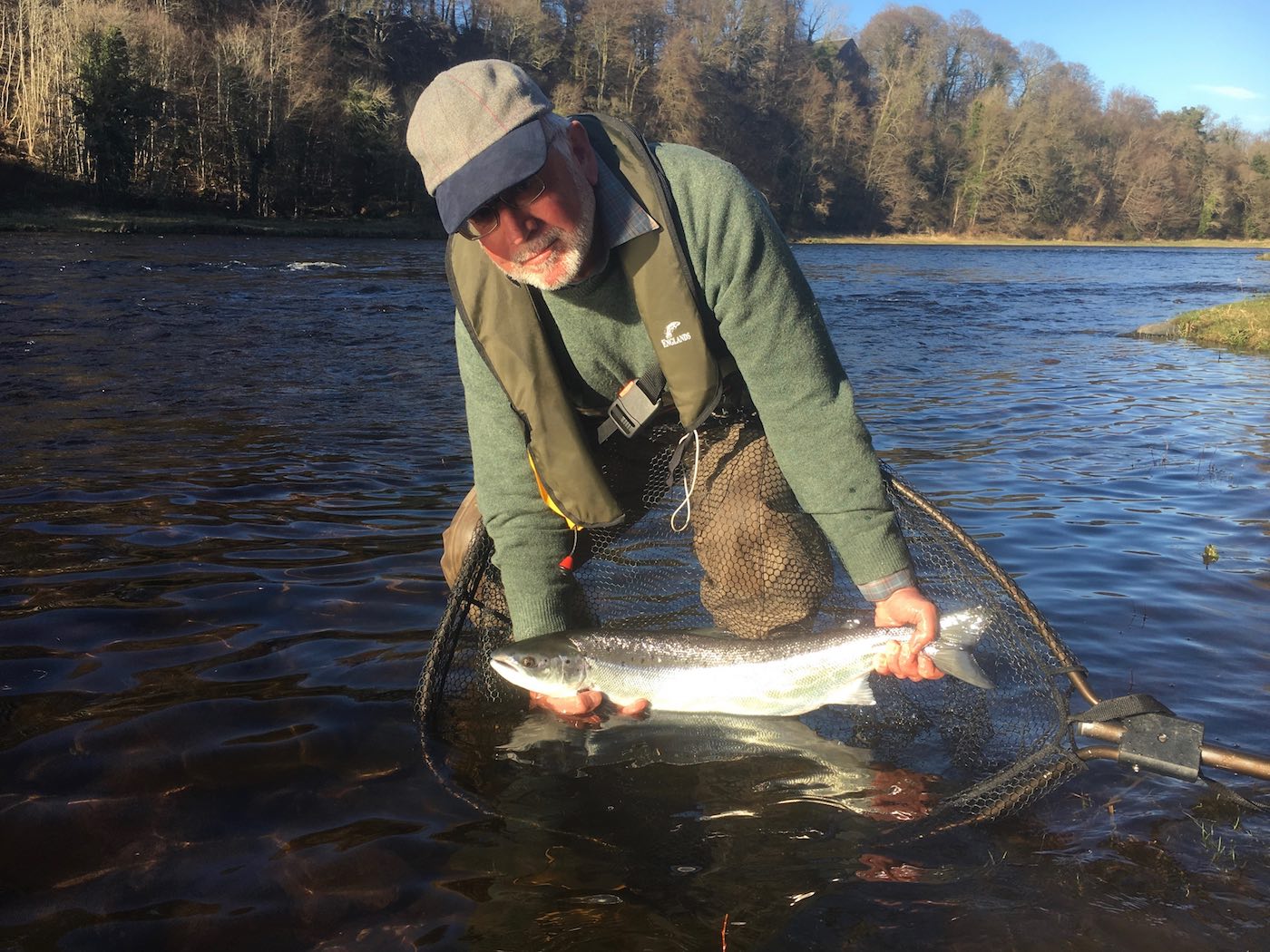 Here's salmon fisher Chris Blandford with a perfect fly caught River Tay Spring salmon which he caught near the Perthshire town of Stanley during March while I was his salmon fishing guide. The bright clear sky Spring sunlight illuminated this salmon's beautiful silver flanks for this perfect salmon capture shot which I took.