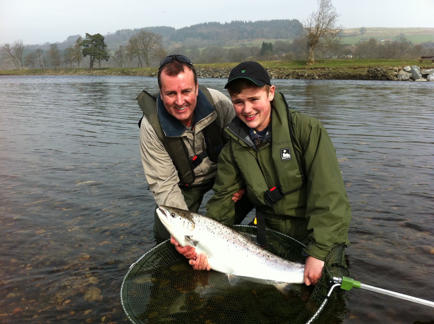 This young man landed 2 almost identical heavyweight Spring salmon during late March on the River Tay. He achieved this after a 30 minute crash course on how to use a double handed salmon rod on the Ash Tree Pool of the River Tay near Pitlochry. This was the 2nd Spring salmon he caught so I took this shot of him and his father while accompanying them as their personal salmon fishing guide. What a memorable morning that was!