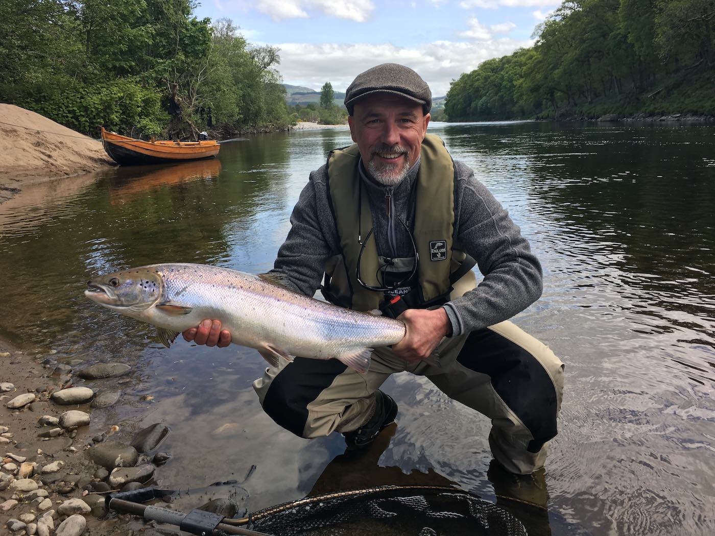 This fine Spring salmon was hooked from the boat in the Rock Pool on Upper Kinnaird during the Spring month of May by this guided salmon fishing trip client. This happy salmon fisher was just as surprised as I was when the rod in the boat buckled around as the lure had only been fishing for less than 30 seconds! You can see the traditional larch built salmon fishing boat in the background moored up on the sand bank.