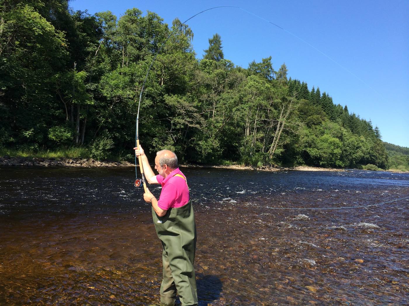 Here's an angler out on the River Tummel in the middle of a Spey casting lesson. The Spey cast is a highly functional salmon fly delivery cast which allows the fly fisher to present the fly when there's no room behind for an overhead cast. Many salmon anglers come to learn this casting technique while salmon fishing in Scotland with a professional fly fishing instructor.
