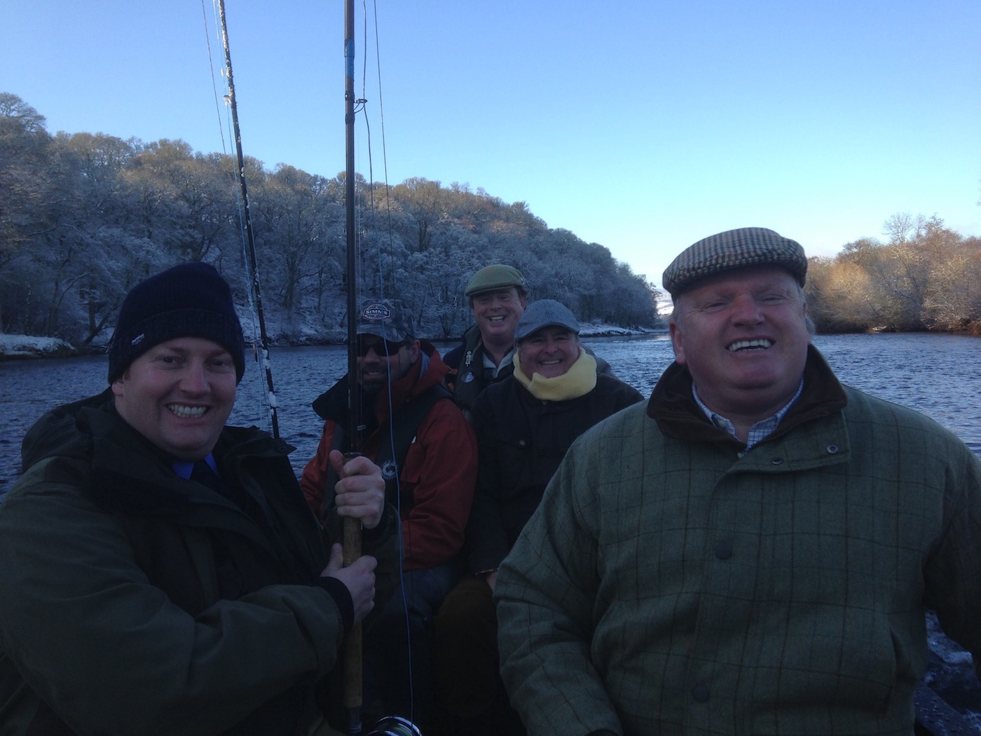 You can see the frozen riverbanks behind this group of celebrating River Tay salmon fishers. This was an opening day party out in the boat near Pitlochry. Early January is a highly picturesque time to be out salmon fishing as long as you wrap up well like these salmon fishers did.