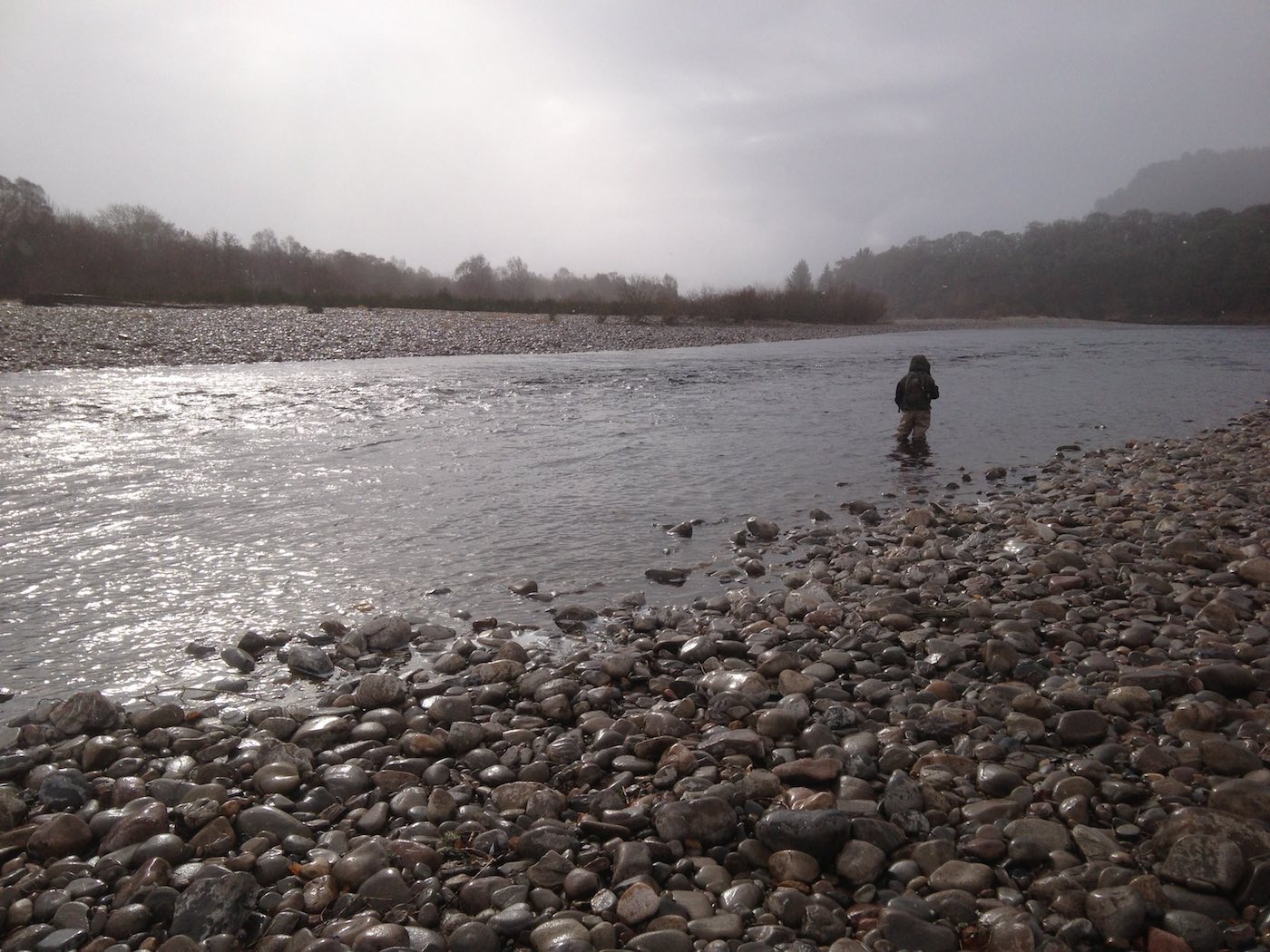 This salmon fishing holiday angler is fly fishing through the Mike's Run Pool of the River Tummel during a cold & wet early Spring day. I just had to grab this shot as his salmon guide when the sun appeared through the clouds as it was far too spectacular a light show moment to ignore.