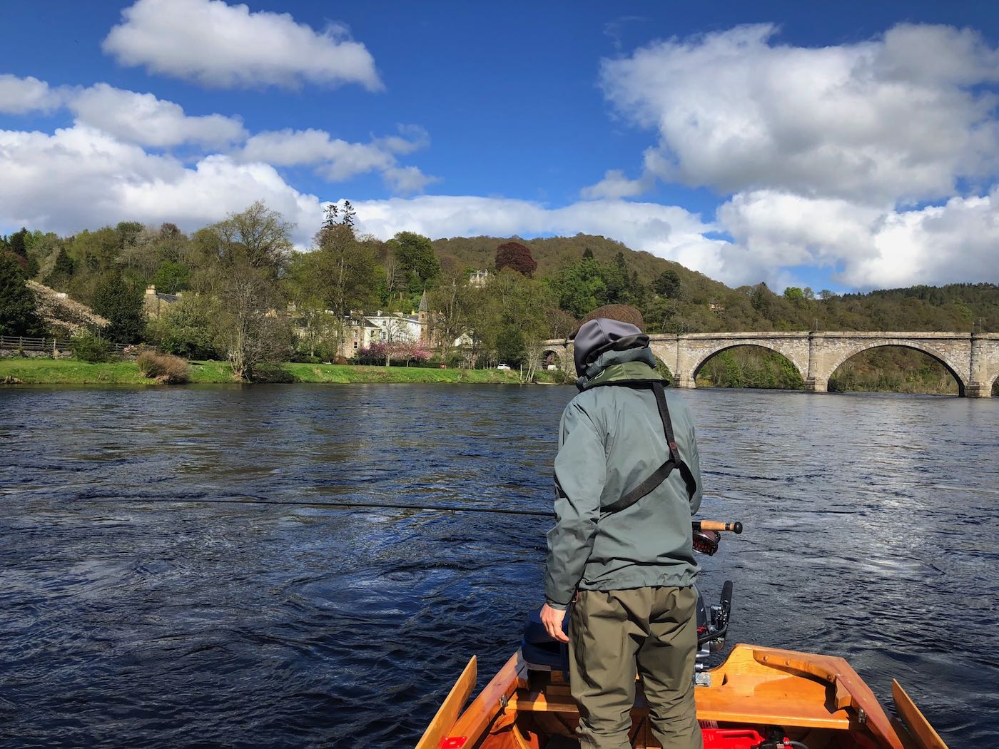 Here's a salmon fishing holiday guest in the traditional Tay salmon boat at the Telford Bridge in Dunkeld. You've got to manage your expectations in salmon fishing and stay consistent with a well thought out fishing plan and when you do that results will always follow. Note this salmon fisher is wearing a life jacket which is mandatory with all of our guided salmon fishing guests.