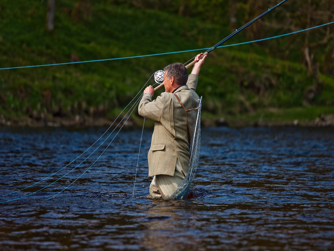 Here's a fabulous action photograph of Jock Monteith loading up a perfect Spey cast for long range salmon fly delivery across the River Tay with his tweed jacket and chest waders on. This shot was captured on the Meetings Pool of the Lower Kinnaird Beat by top Scottish photographer Louise Bellin.