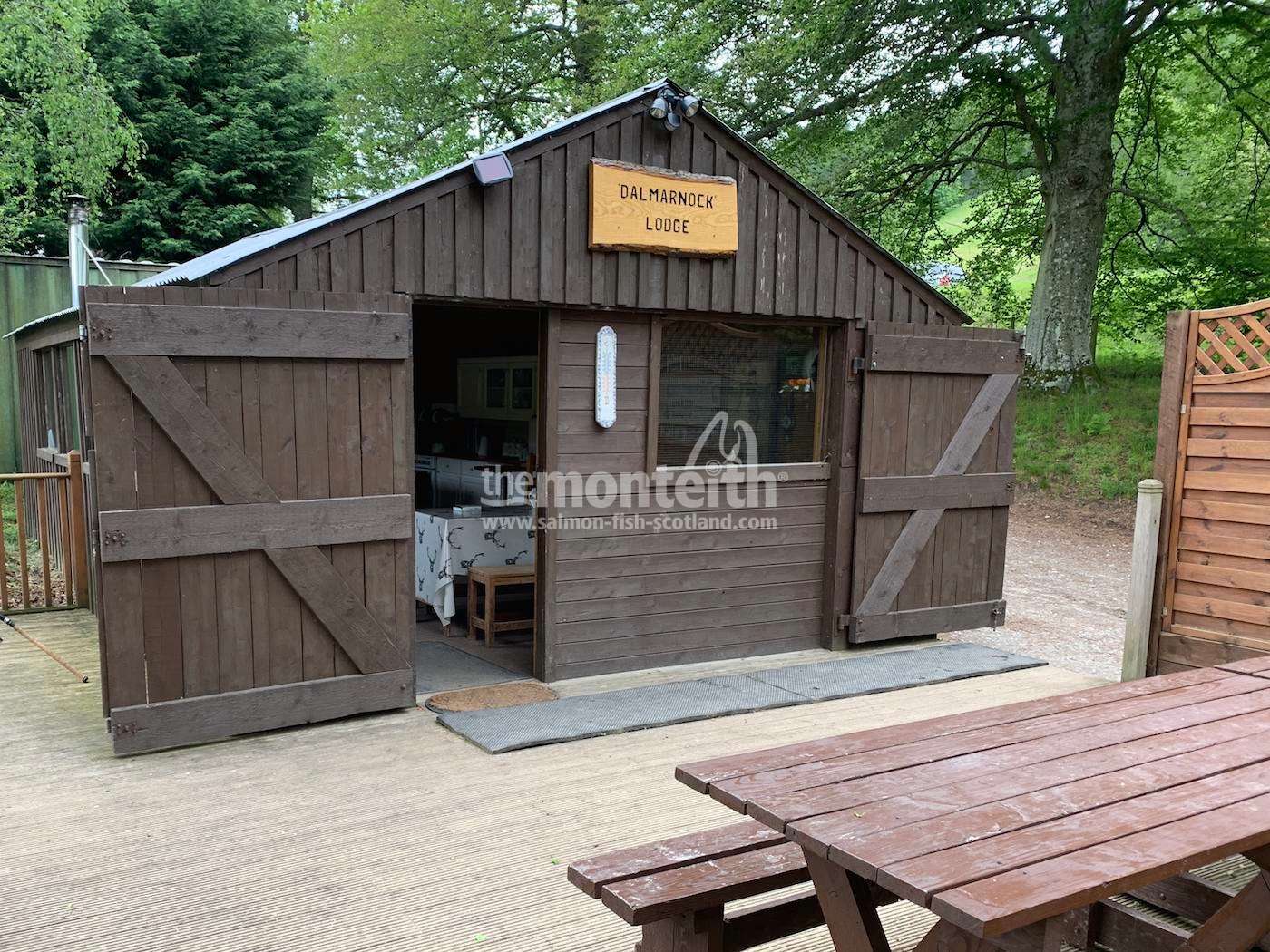 The Dalmarnock fishing hut front elevation faces directly downstream to the Inch Pool where the movement of salmon can be observed during lunch. This River Tay salmon beat is nearly 3 miles in length and is located close to Dunkeld. Look at the lovely hand made Dalmarnock sign and the sliding security door. The decking area and table is where our salmon fishing trip guests eat their lunch during periods of good weather.