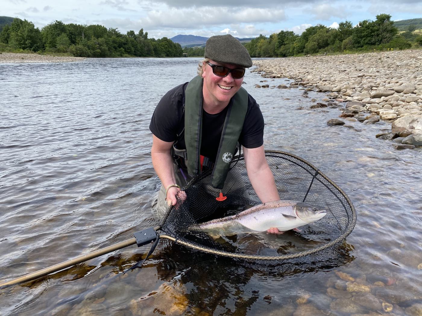 Look at the smile on this salmon angler's face moments after landing this perfect Summer salmon from the River Tay in Perthshire. Catching a salmon like this on the fly takes skill, patience and a good tactical understanding of how to fish your fly effectively. This 14lbs Summer salmon is being held in the McLean landing net for this photo before being released.