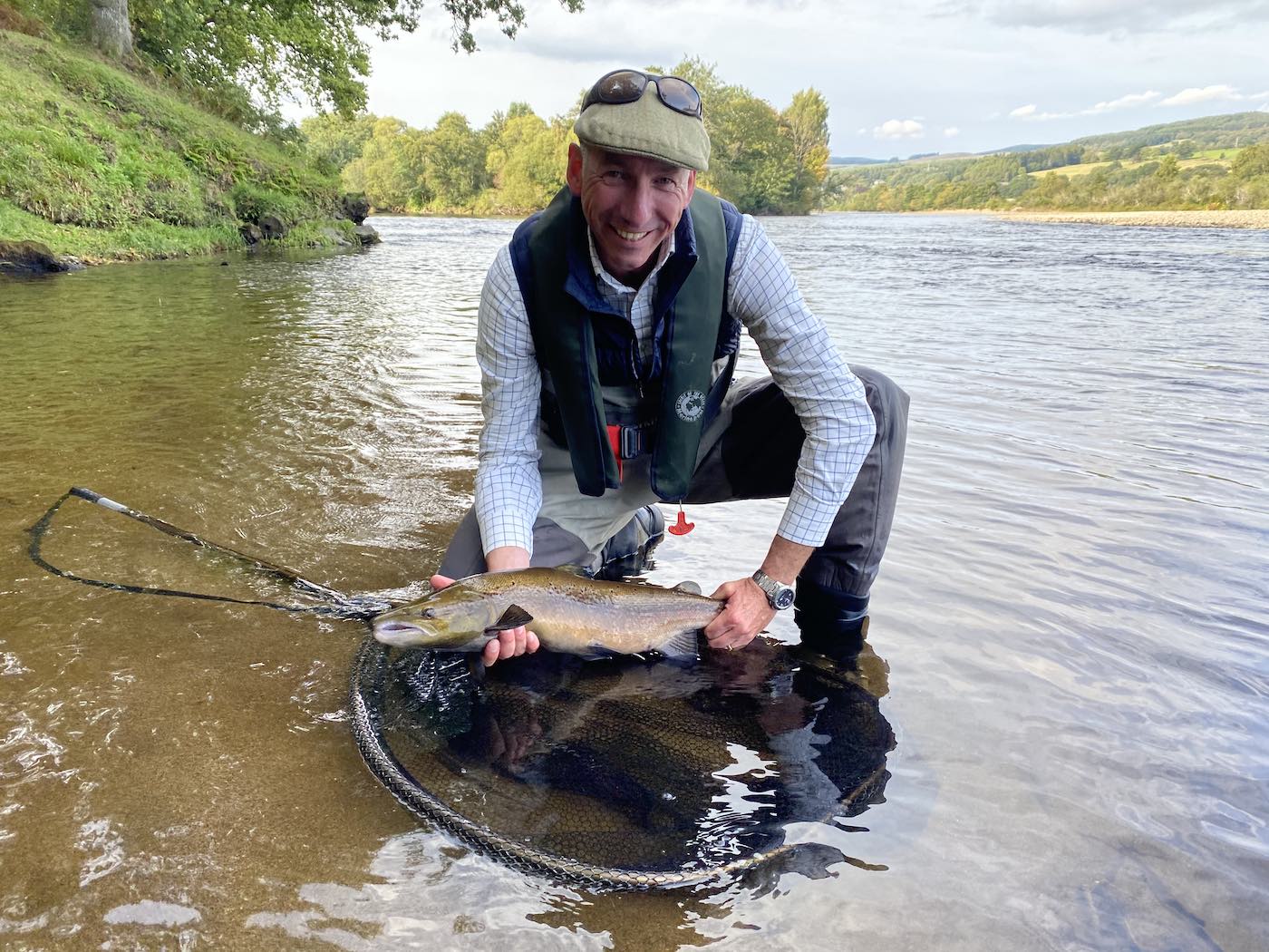 This River Tay guided salmon fishing guest just captured his first ever fly caught salmon hence the big smile on his face. Booking a professional guide that has the nose of the native otter is vital for giving you the best chance of salmon fishing success. This fish was caught at the Tummel Tay confluence which you can see in the background opposite the overhanging oak tree branches.
