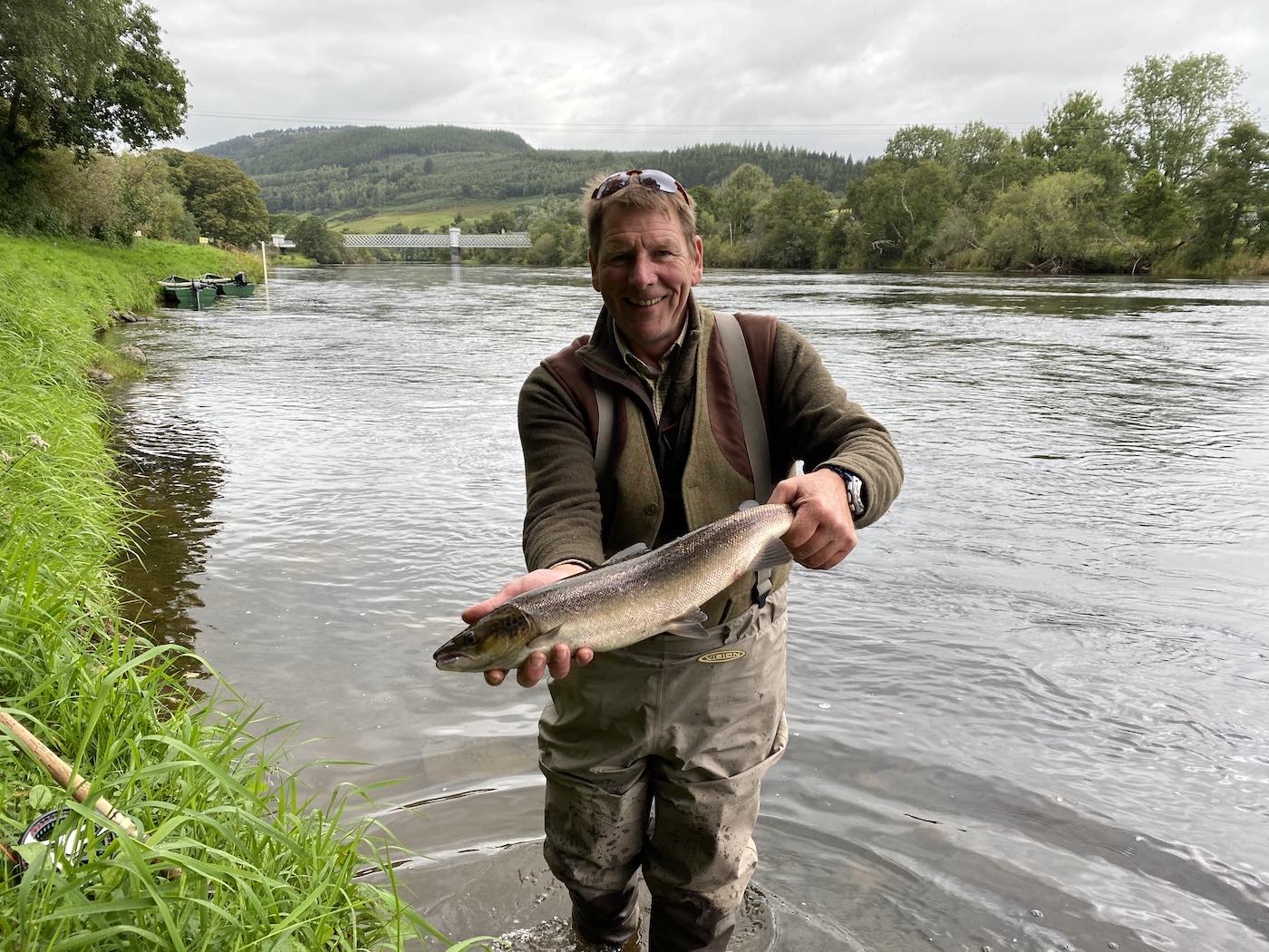 This professional guide from the River Dee is holding 1 or 3 salmon landed that August day. John Fyfe came down from the River Dee to be guided by Jock Monteith who is renowned for his excellent guiding abilities. This salmon was caught on the Upper Kinnaird salmon beat at the Daffodil Lie Pool which is immediately downstream of the Logierait Bridge which is clearly visible in this picture.
