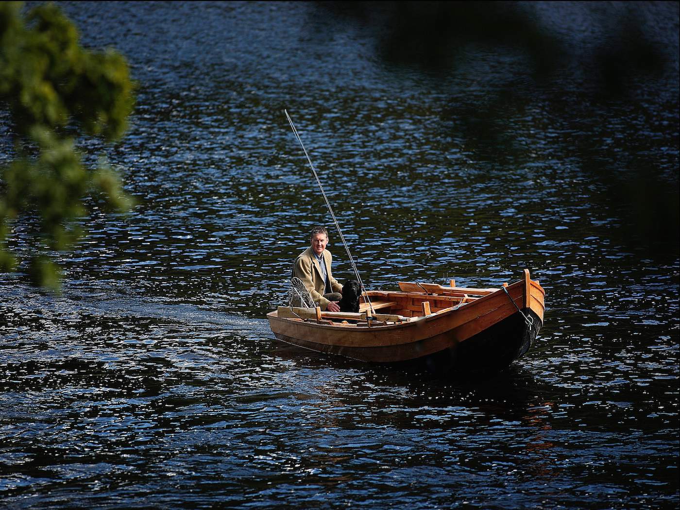 This Tay 'coble' boat was hand made by famous River Tay boatbuilder John Ferguson who's based in Stanley in the Tay Valley. These traditional salmon fishing boats serve many different fishing applications and are a pleasure to be out on the Tay in one for the day. This photograph of me in the boat with my fly rod & my labrador dog 'Selkie' was taken in the Cottar Pool on the Newtyle Beat of the River Tay by professional photographer Peter Sandground.
