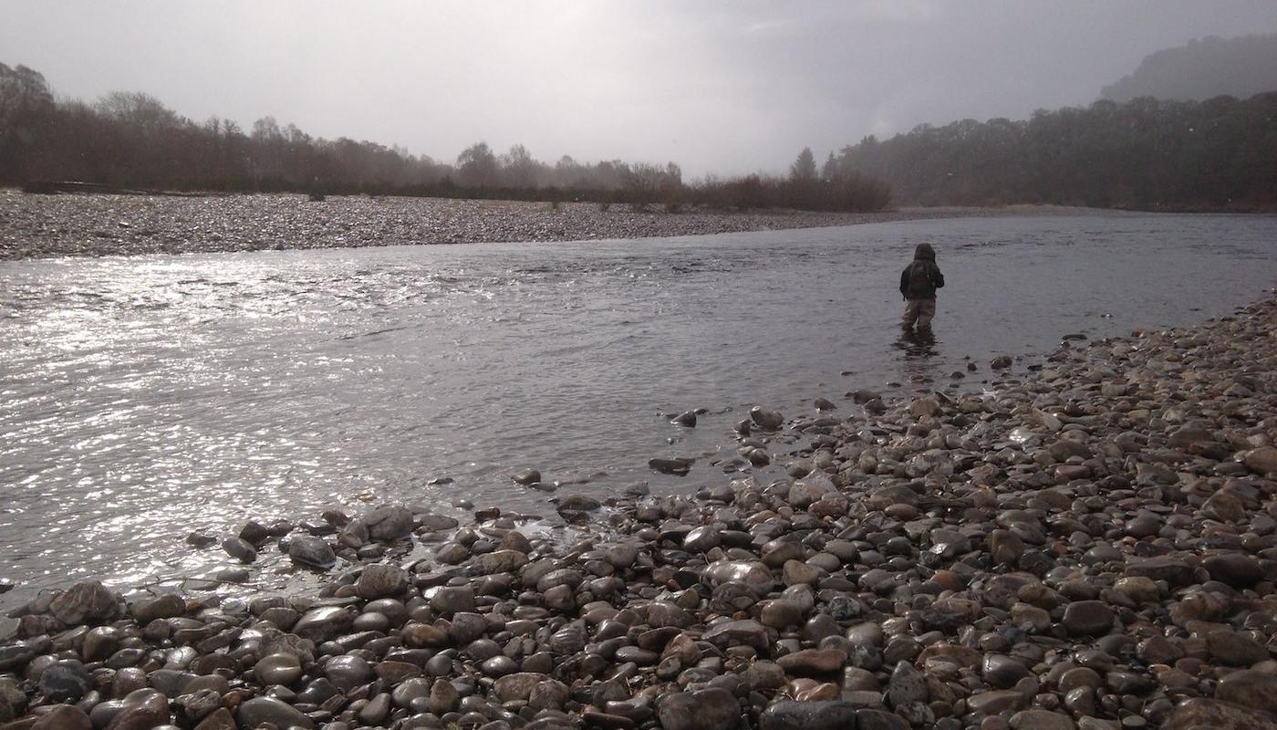 This salmon fishing holiday angler is fly fishing through the Mike's Run Pool of the River Tummel during a cold & wet early Spring day. I just had to grab this shot as his salmon guide when the sun appeared through the clouds as it was far too spectacular a light show moment to ignore.