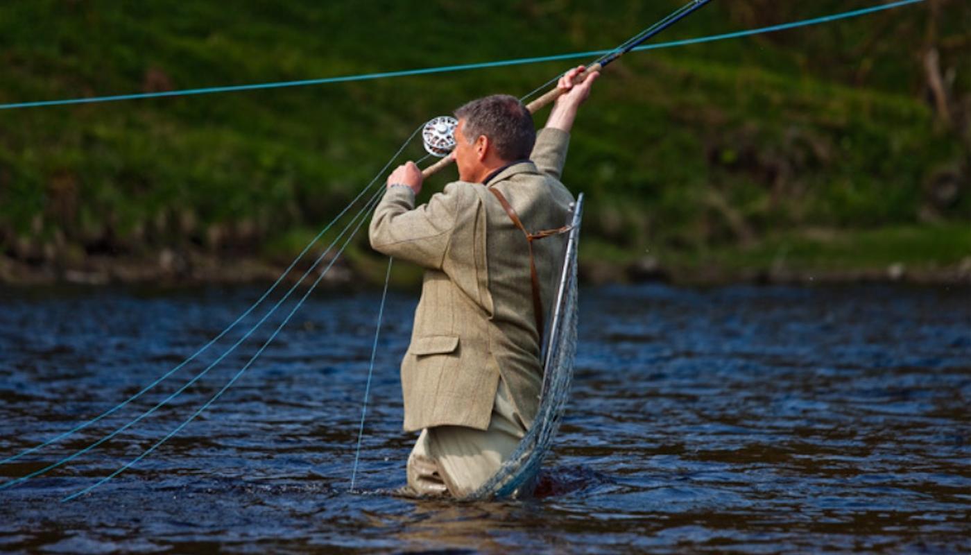 Here's professional Scottish salmon guide Jock Monteith our delivering a long fly fishing line across the River Tay near Dunkeld wearing a traditional heavyweight Tweed jacket that hand been handmade by Haggarts of Aberfeldy.